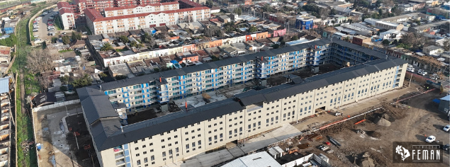 Vista aérea del conjunto habitacional Barrio Maestranza UKAMAU 2, mostrando su diseño en forma de rectángulo con un gran espacio común central.